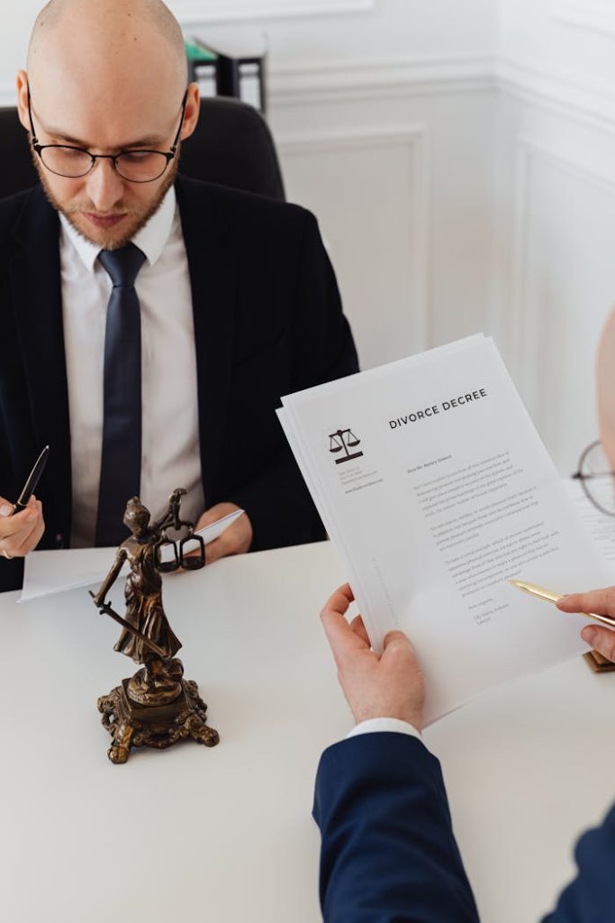 lawyers-reading-divorce-papers-7876039 Two lawyers discussing divorce decree documents in a professional office setting.